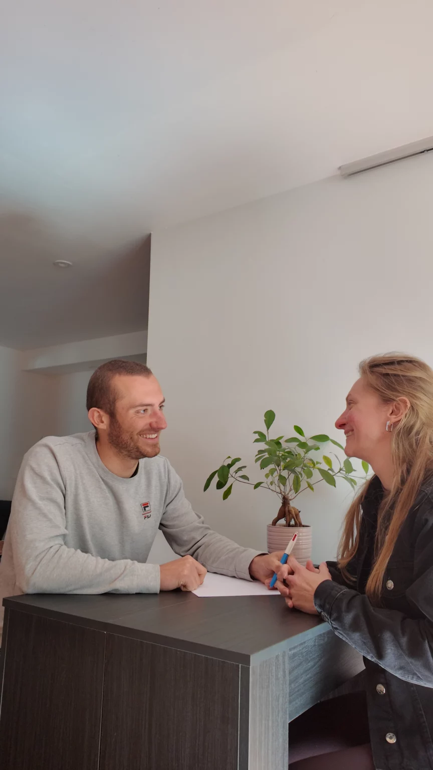 Un conseiller en nutrition assis à une table avec une cliente durant un rendez-vous